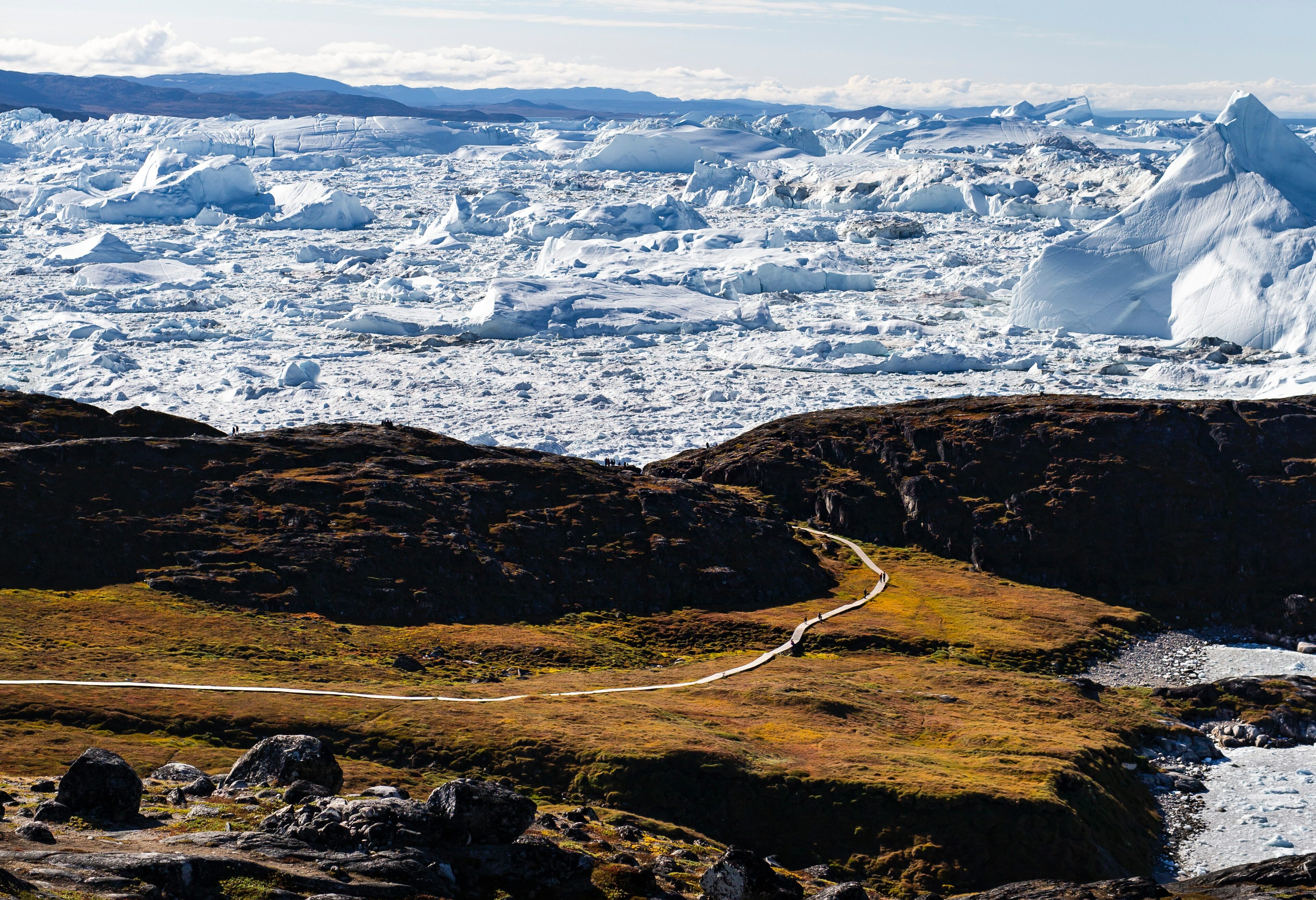 groenland-Ilulissat-wandelaars-met-ijsschotsen-op-achtergrond
