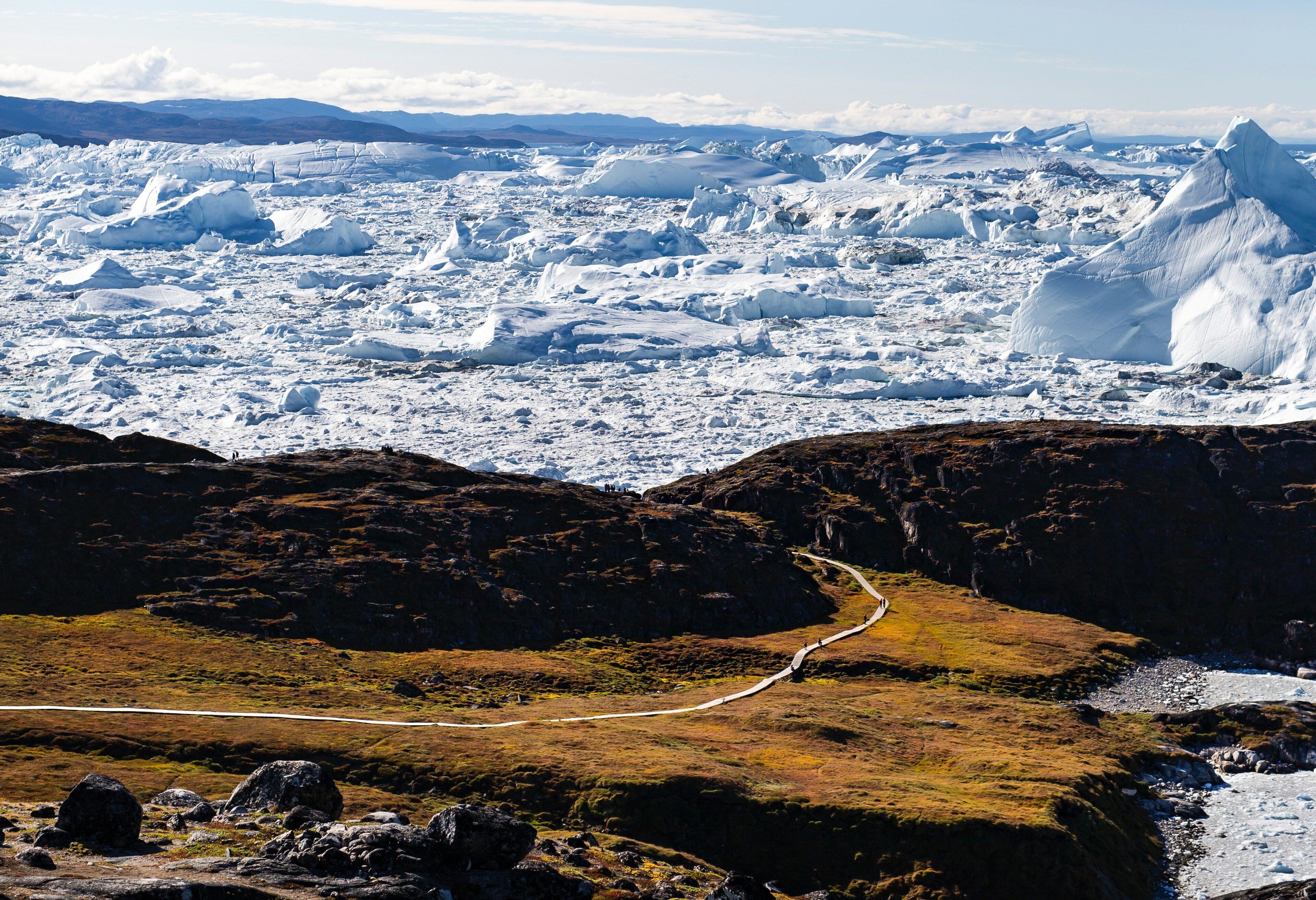 groenland-Ilulissat-wandelaars-met-ijsschotsen-op-achtergrond