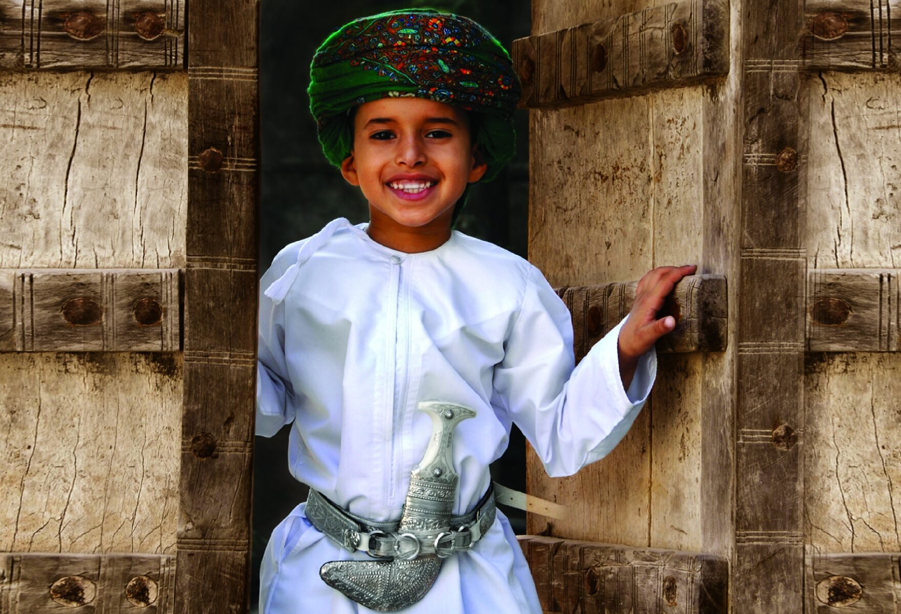 Jongen in Oman bij een oud huis