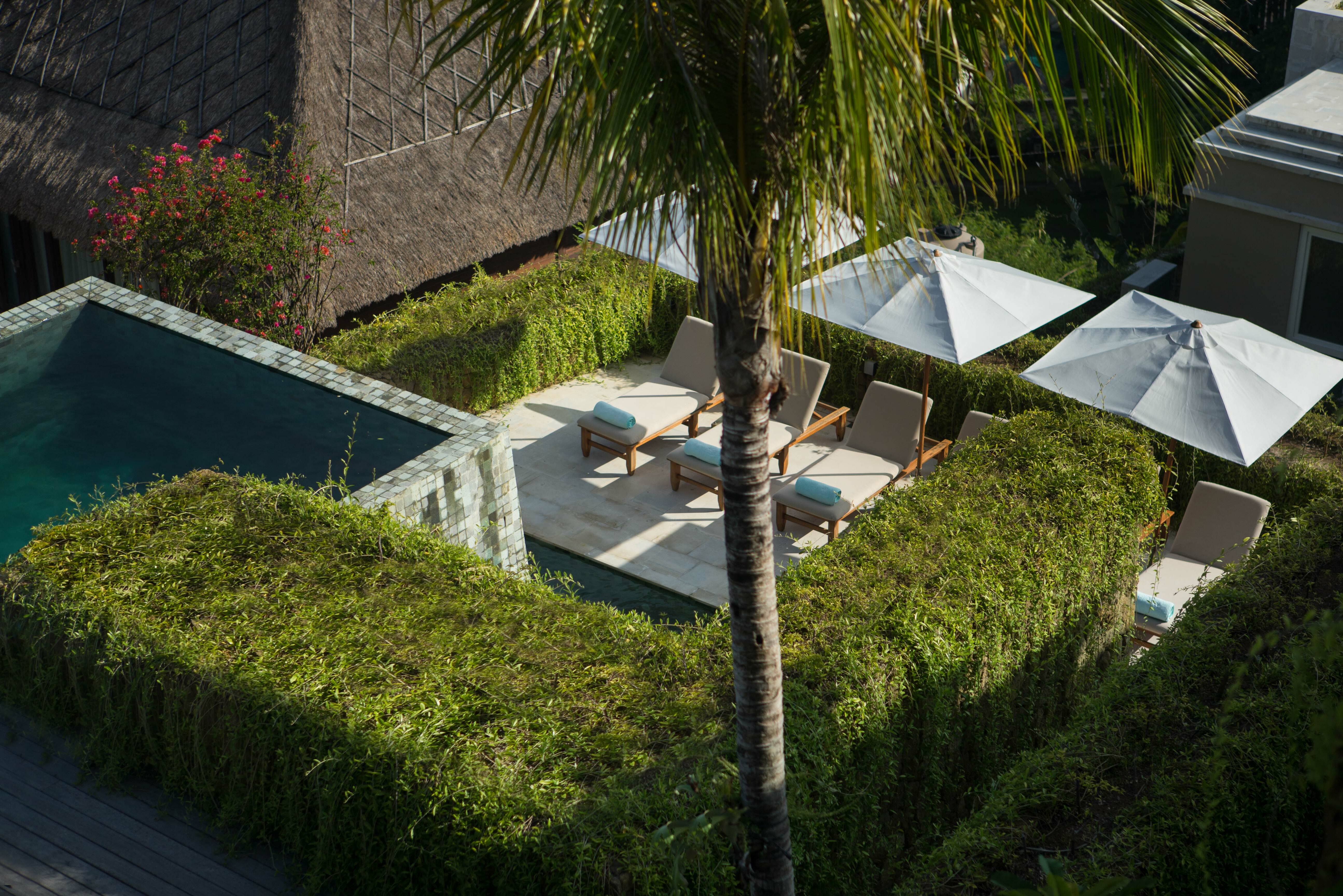 Ligbedjes bij het zwembad van The Tamarind Resort op Nusa Lembongan in Indonesie