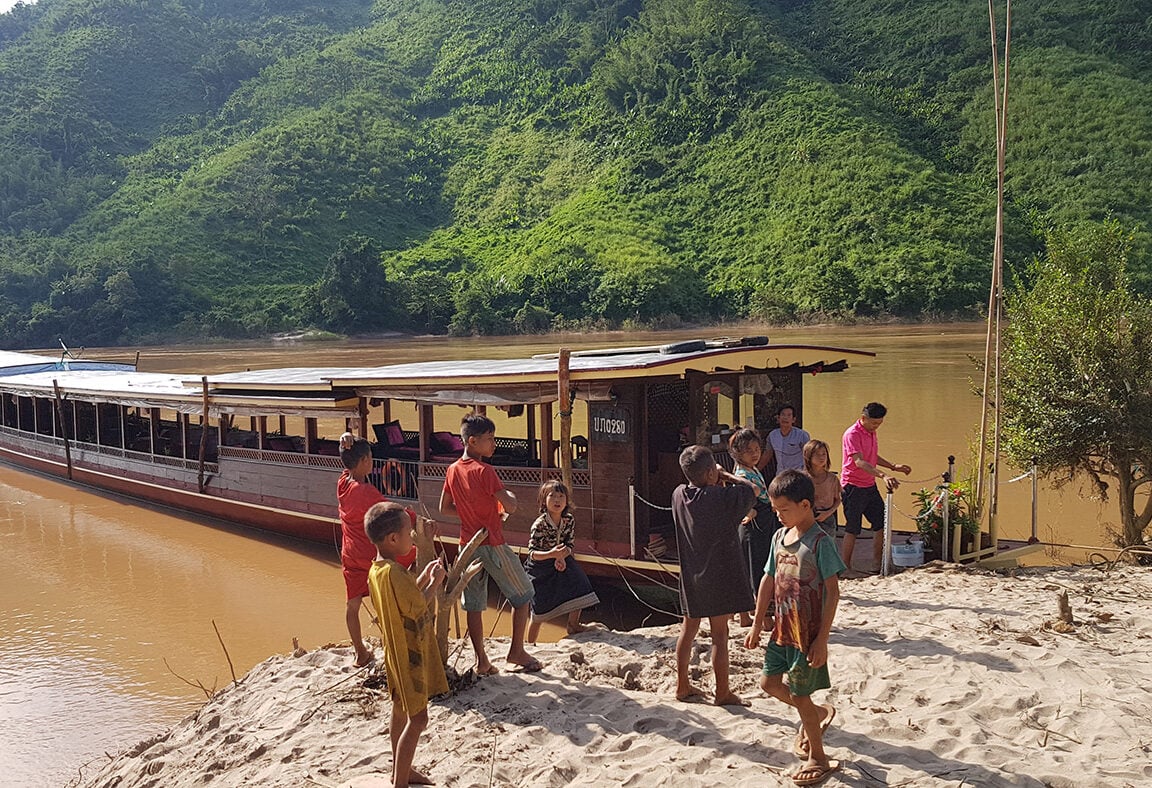 Aanleggen bij een lokaal dorp aan de oever van Mekong rivier met de Shompoo Cruise in Laos