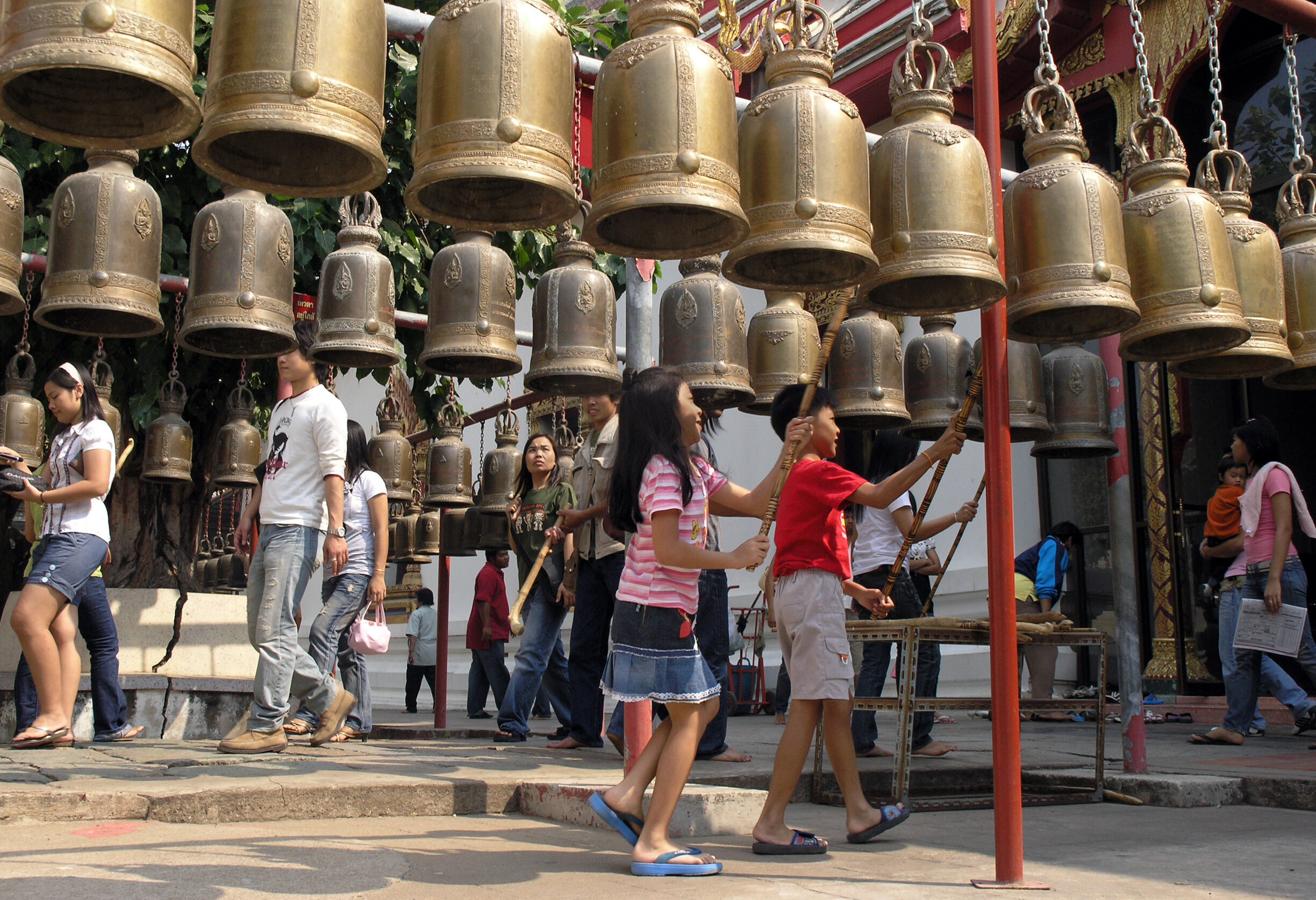 Kinderen luiden boeddhistische bellen bij een tempel in Thailand