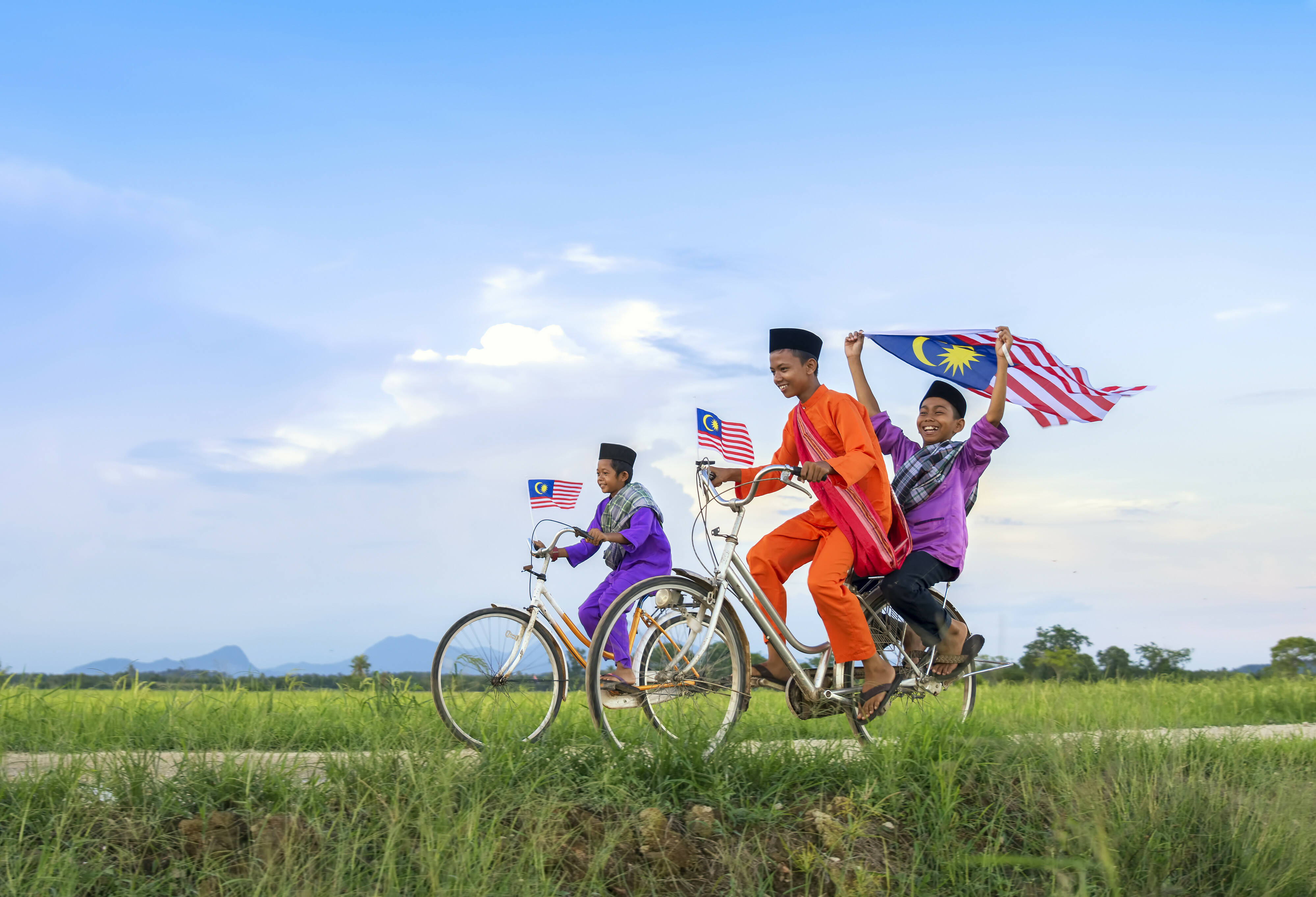 Maleisie Kinderen op een fiets met nationale vlag