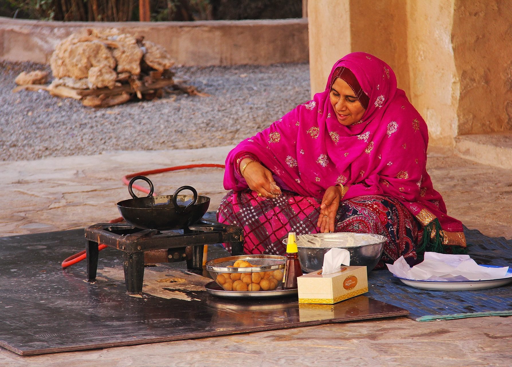 Een Nizwa vrouw aan het koken in Oman