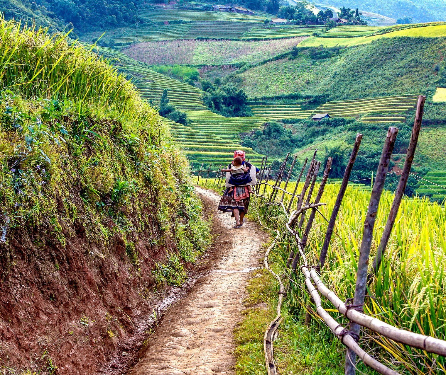 Een vrouw gekleed in traditionele klederdracht wandelt door Sapa. Vietnam