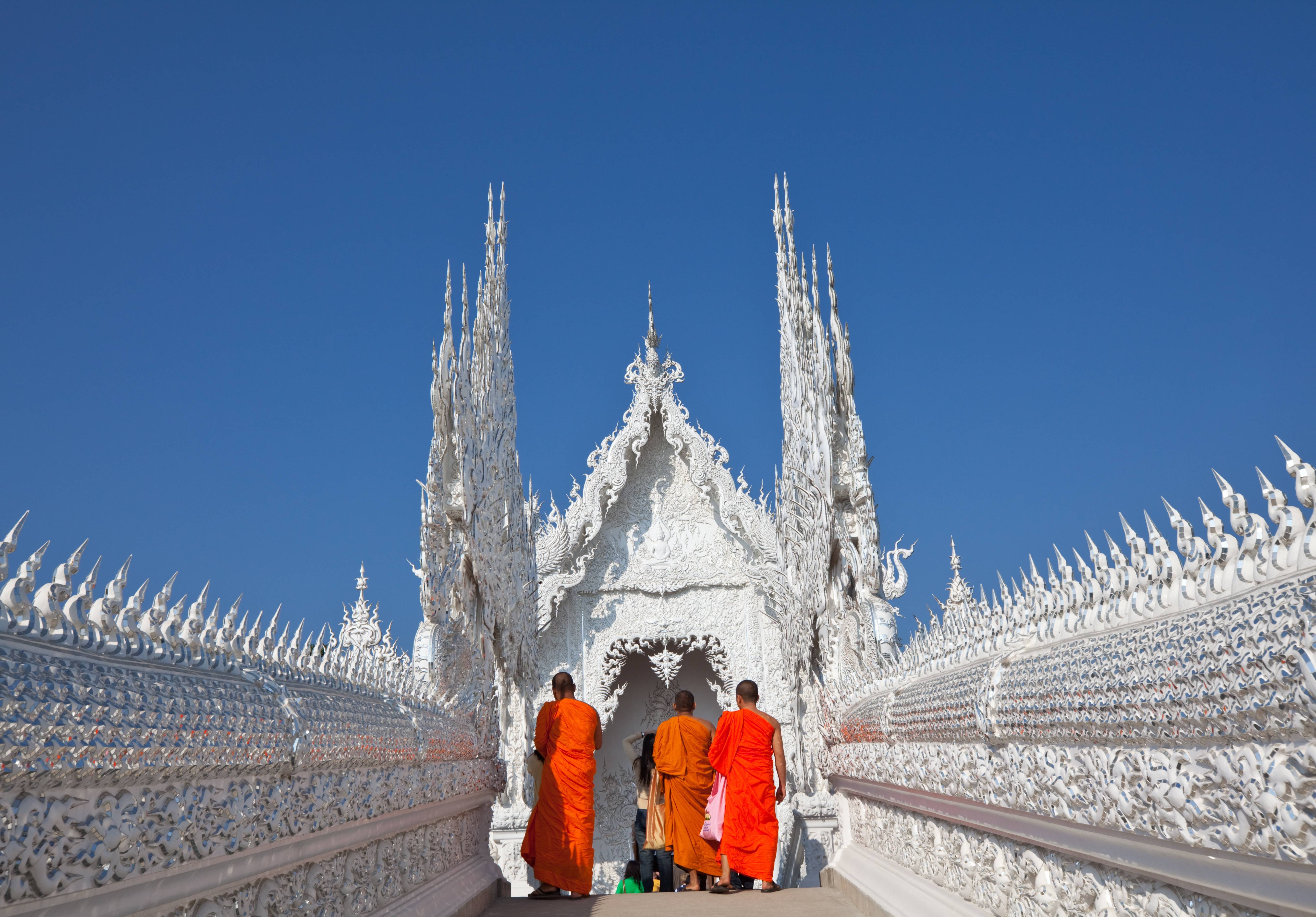 Monniken lopen de Wat Rong Khun tempel in in Chiang Rai, Thailand