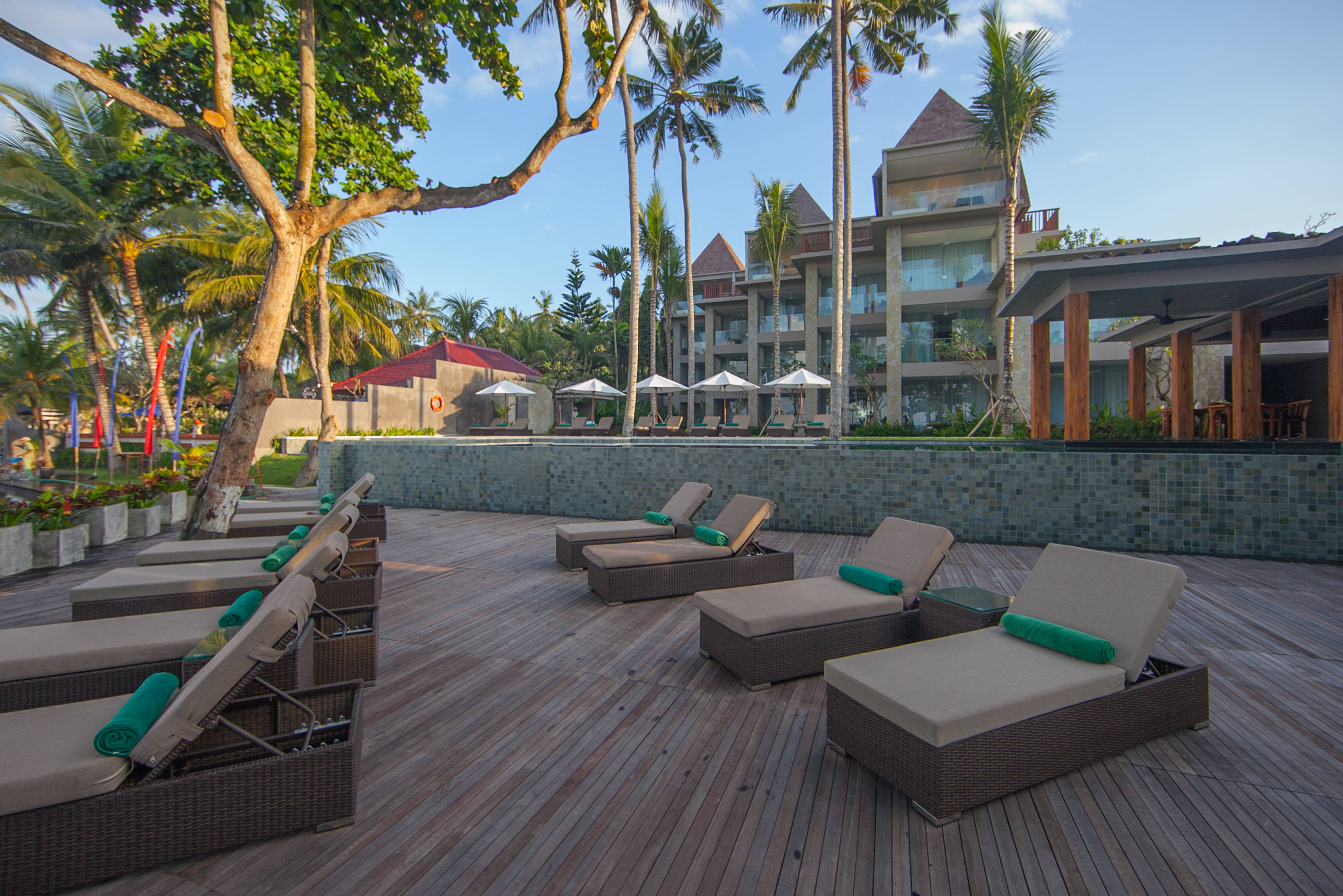 Zonnedek bij het zwembad in het Candi Beach Resort in Candidasa op Bali