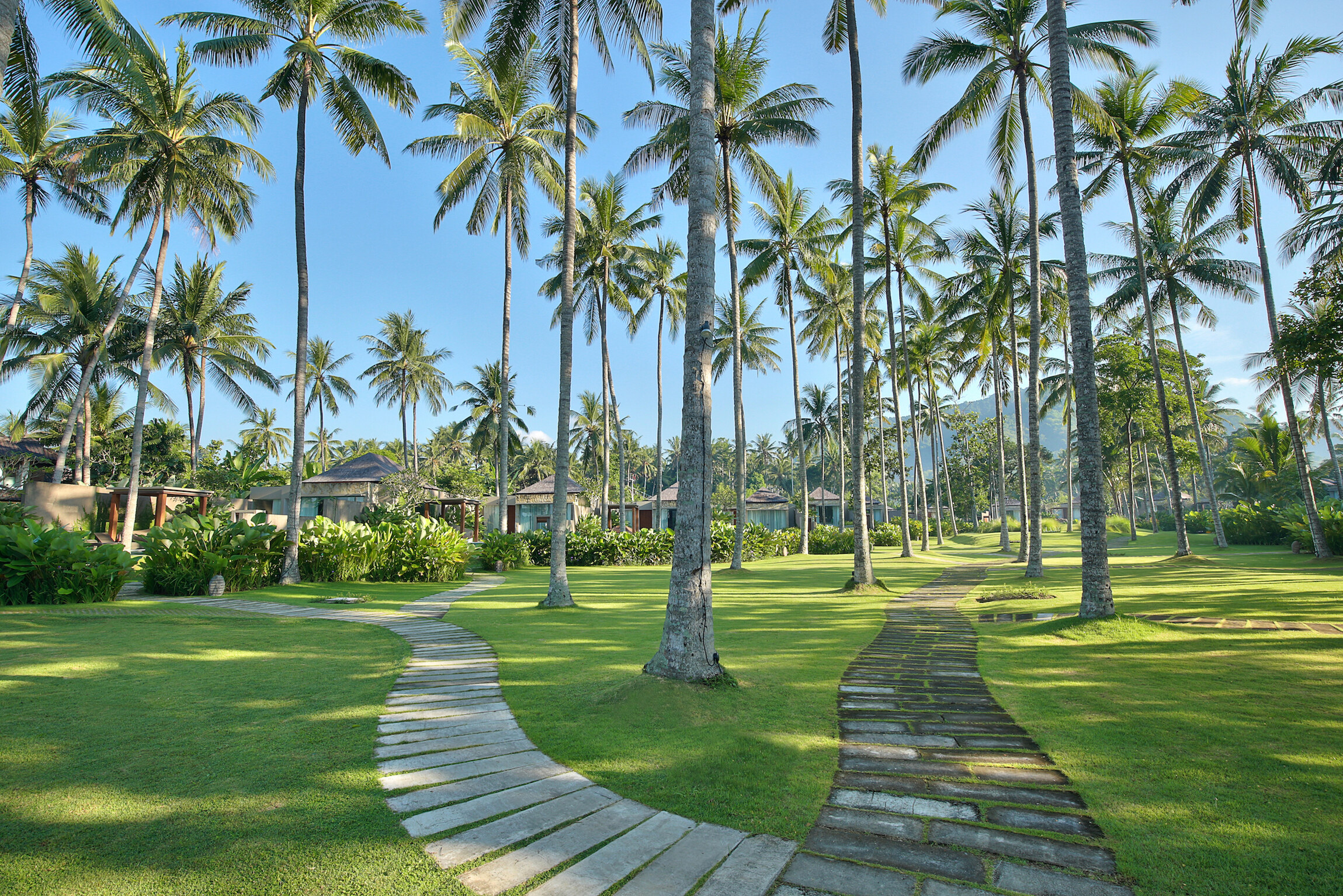 Tropische tuin met joggingpad in het Candi Beach Resort in Candidasa op Bali
