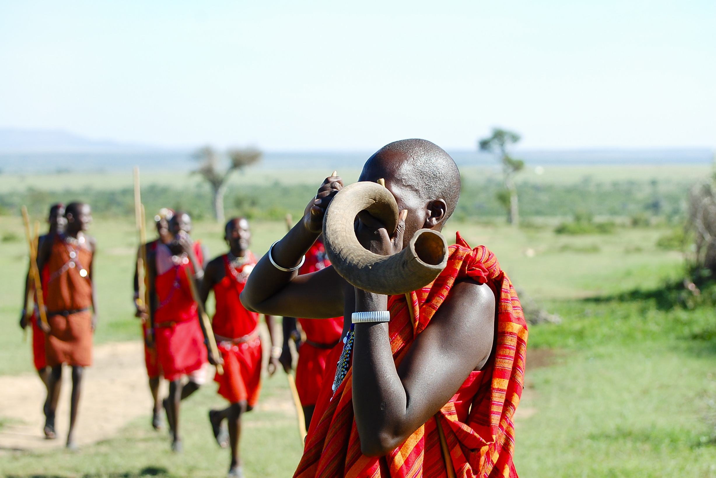 Maasai man blaast op koedoe hoorn in Kenia