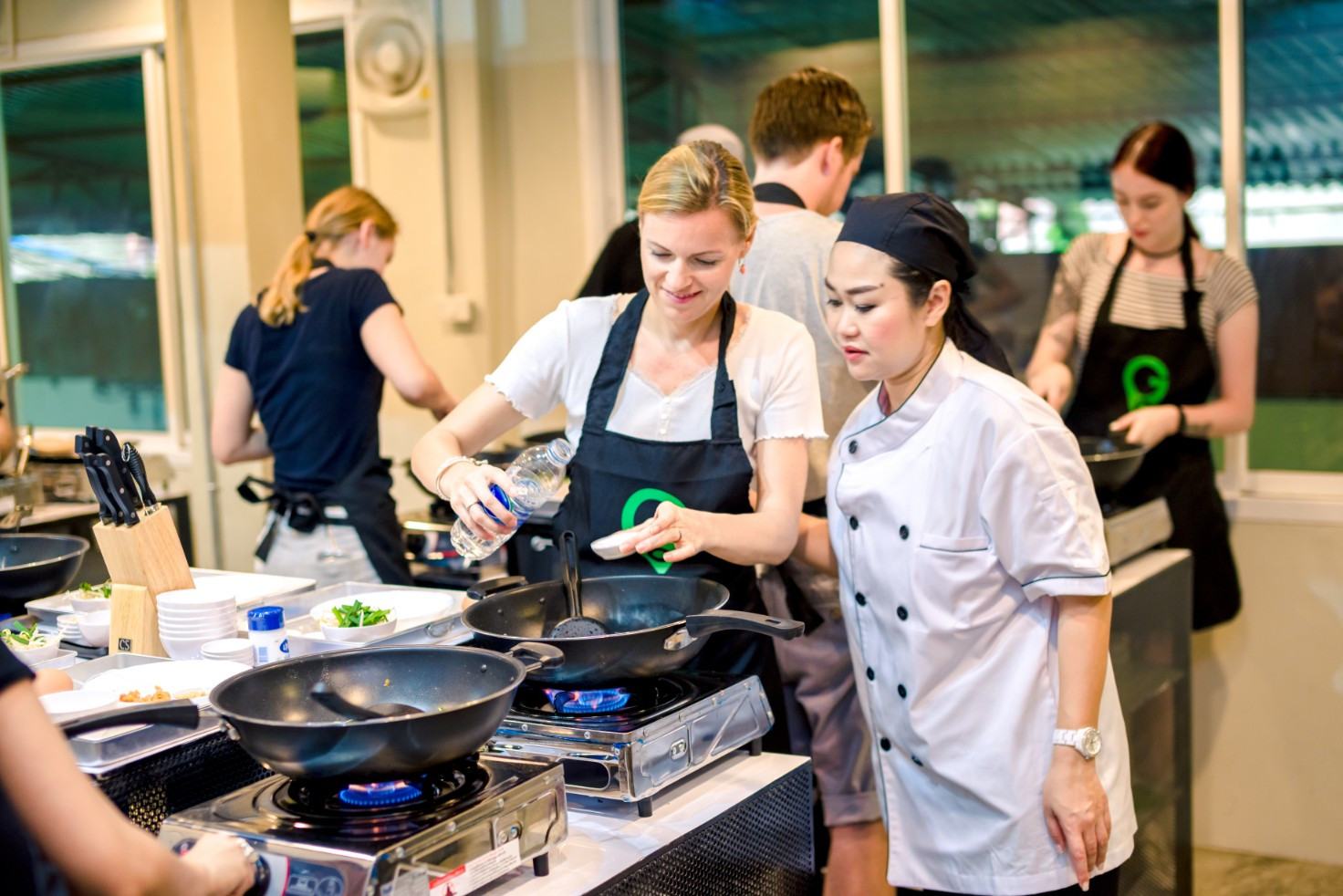 Zelf aan het koken tijdens de Thaise kookcursus in Bangkok, Thailand