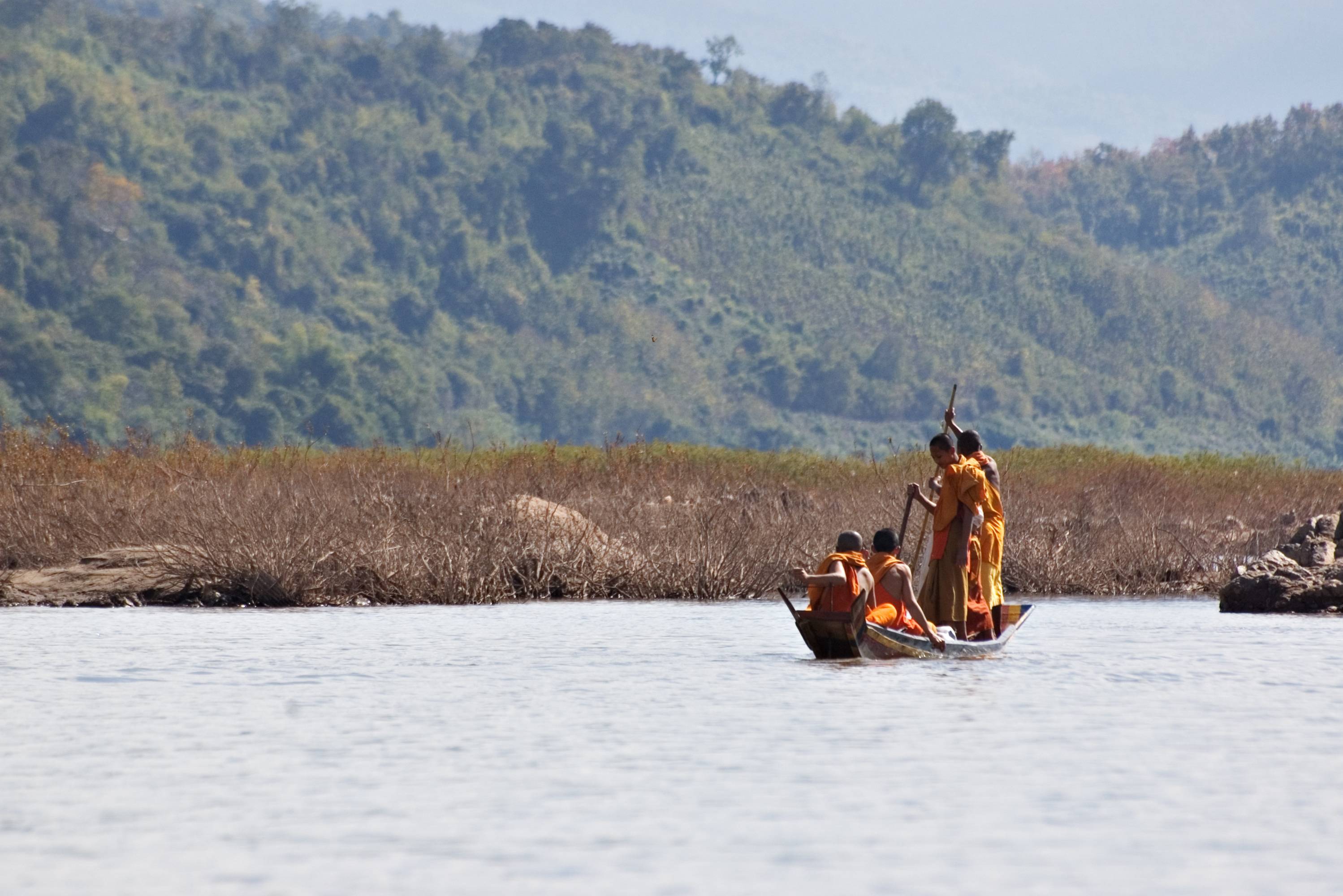 Monniken varen op de Mekong Rivier in Laos