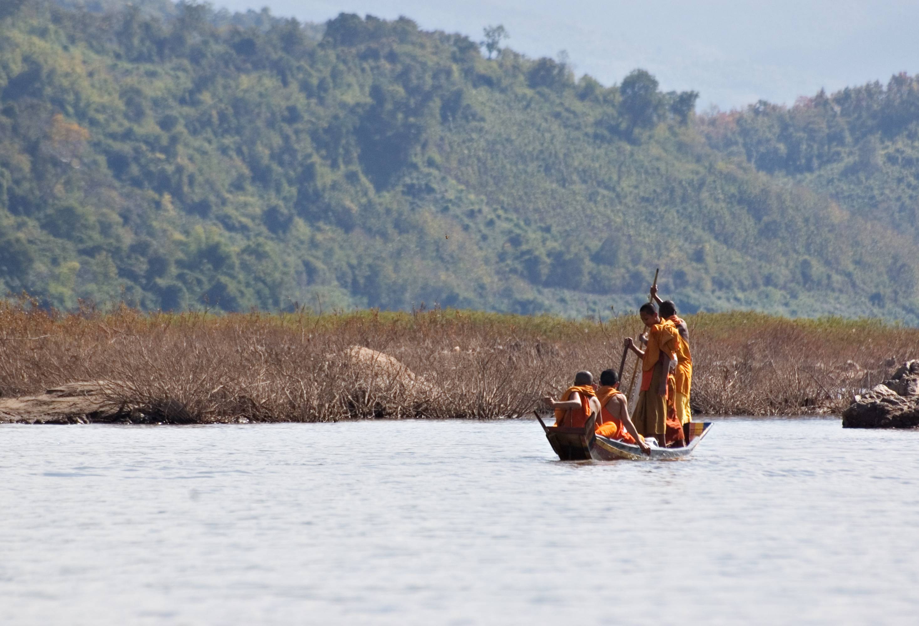 Monniken in een bootje op de Mekong Rivier in Laos