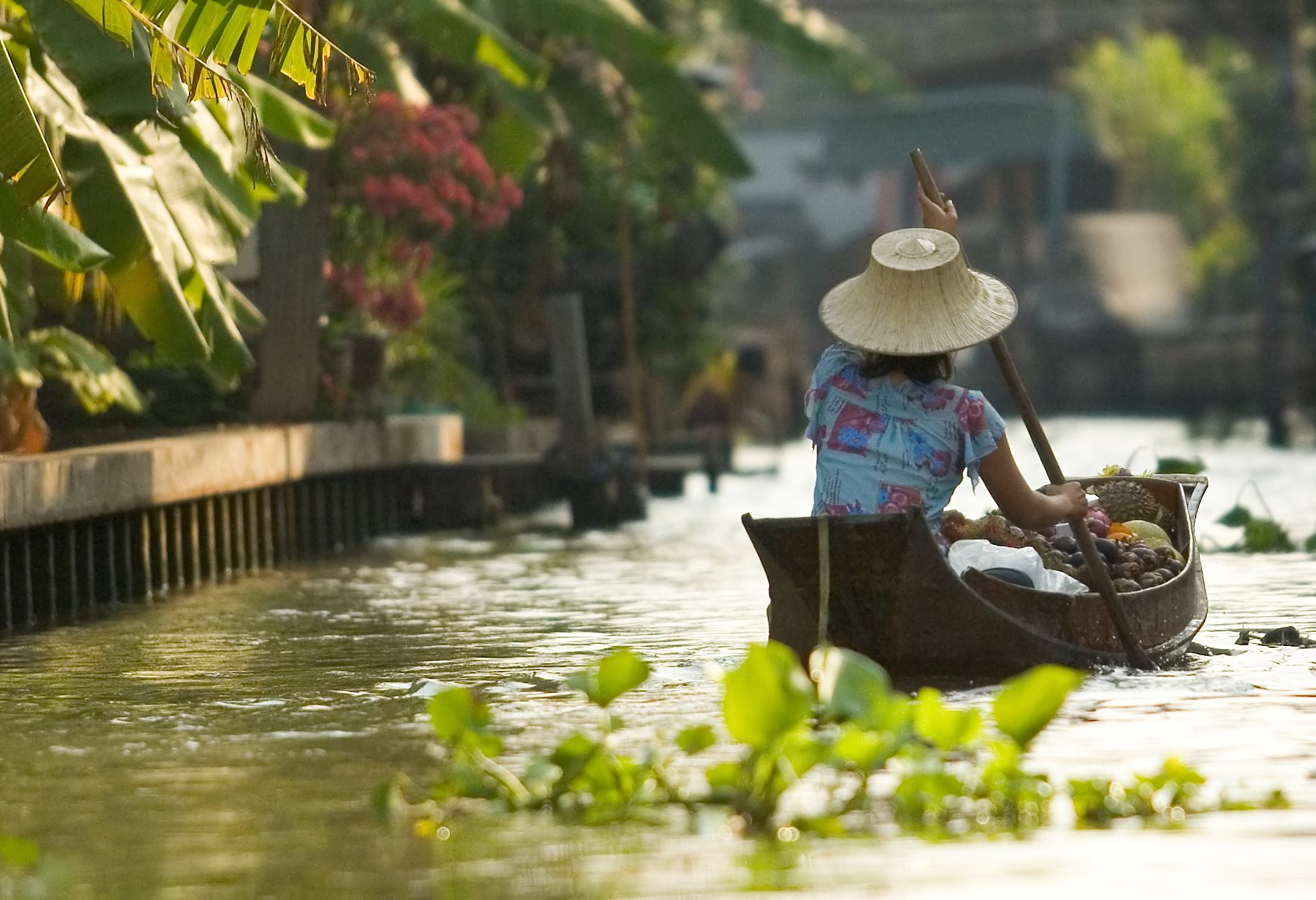 Vrouw vaart door klong in Bangkok, Thailand