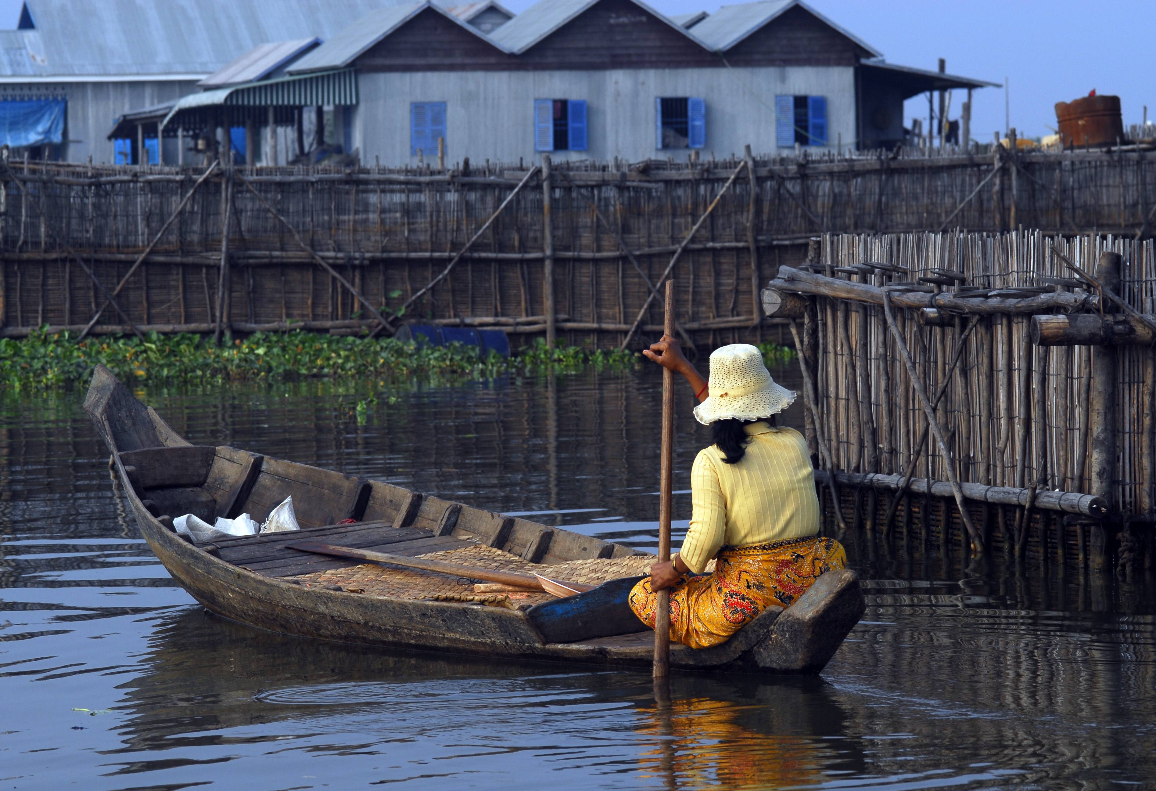 Varen langs een drijvend dorp in het Tonle Sap meer in Cambodja