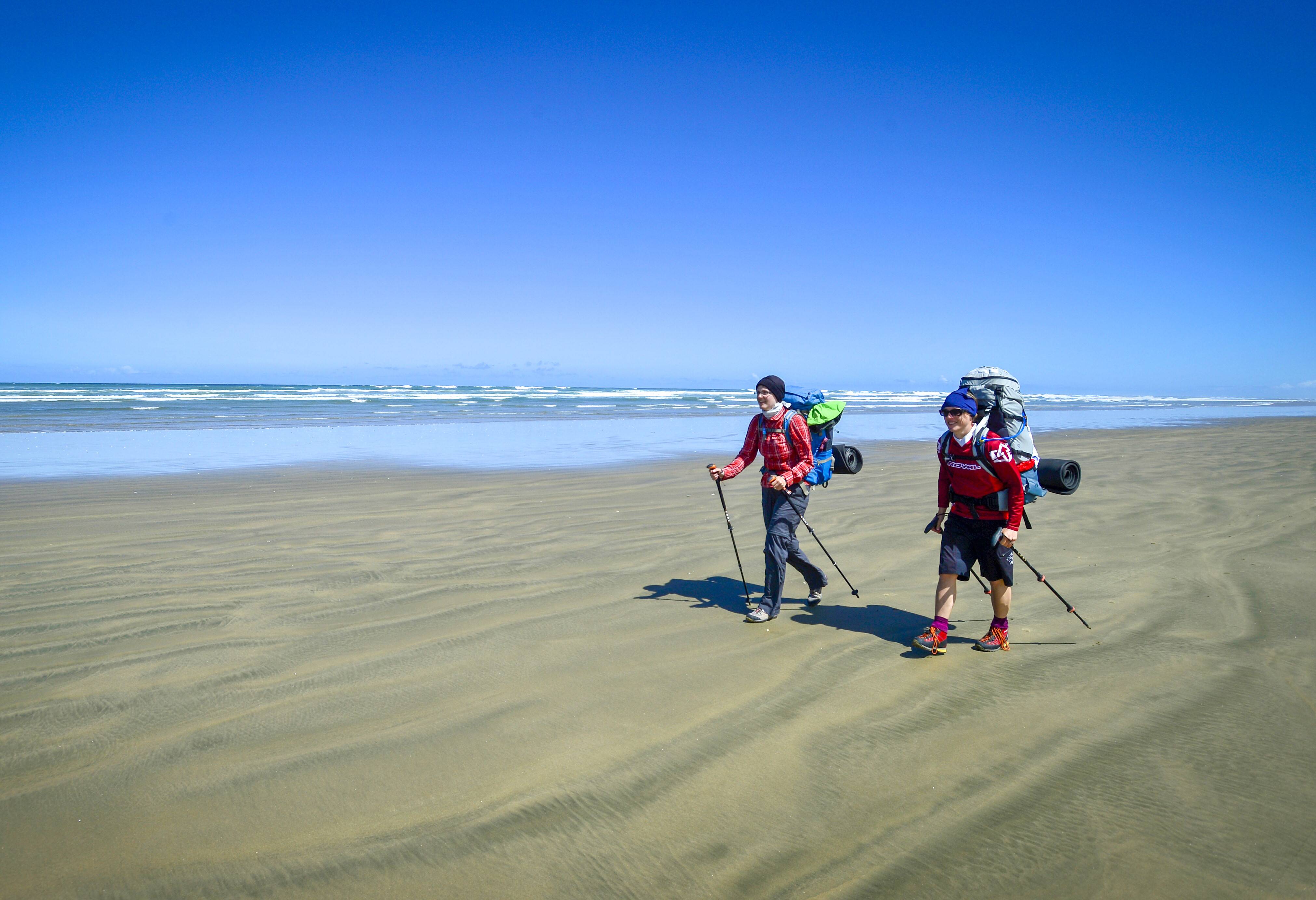 Wandelaars op Ninety Mile Beach in Northland in Nieuw-Zeeland