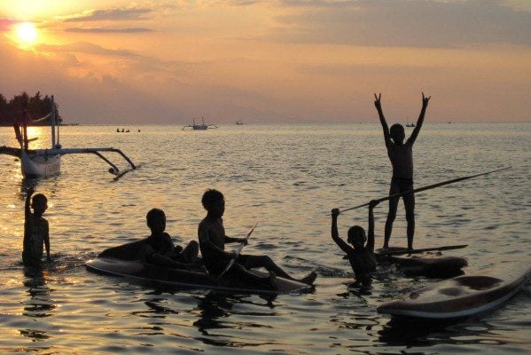 Spelende kinderen bij zonsondergang in Lovina
