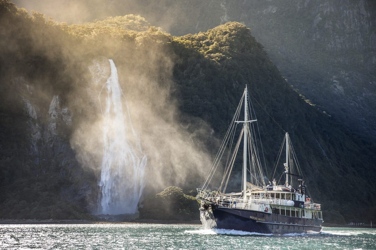De Milford Wanderer boot nabij een waterval in Milford Sound in Nieuw-Zeeland