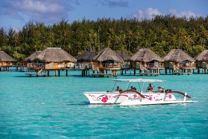 Varen over felblauwe lagune tijdens Bora Bora per Outrigger Kano in Frans-Polynesie
