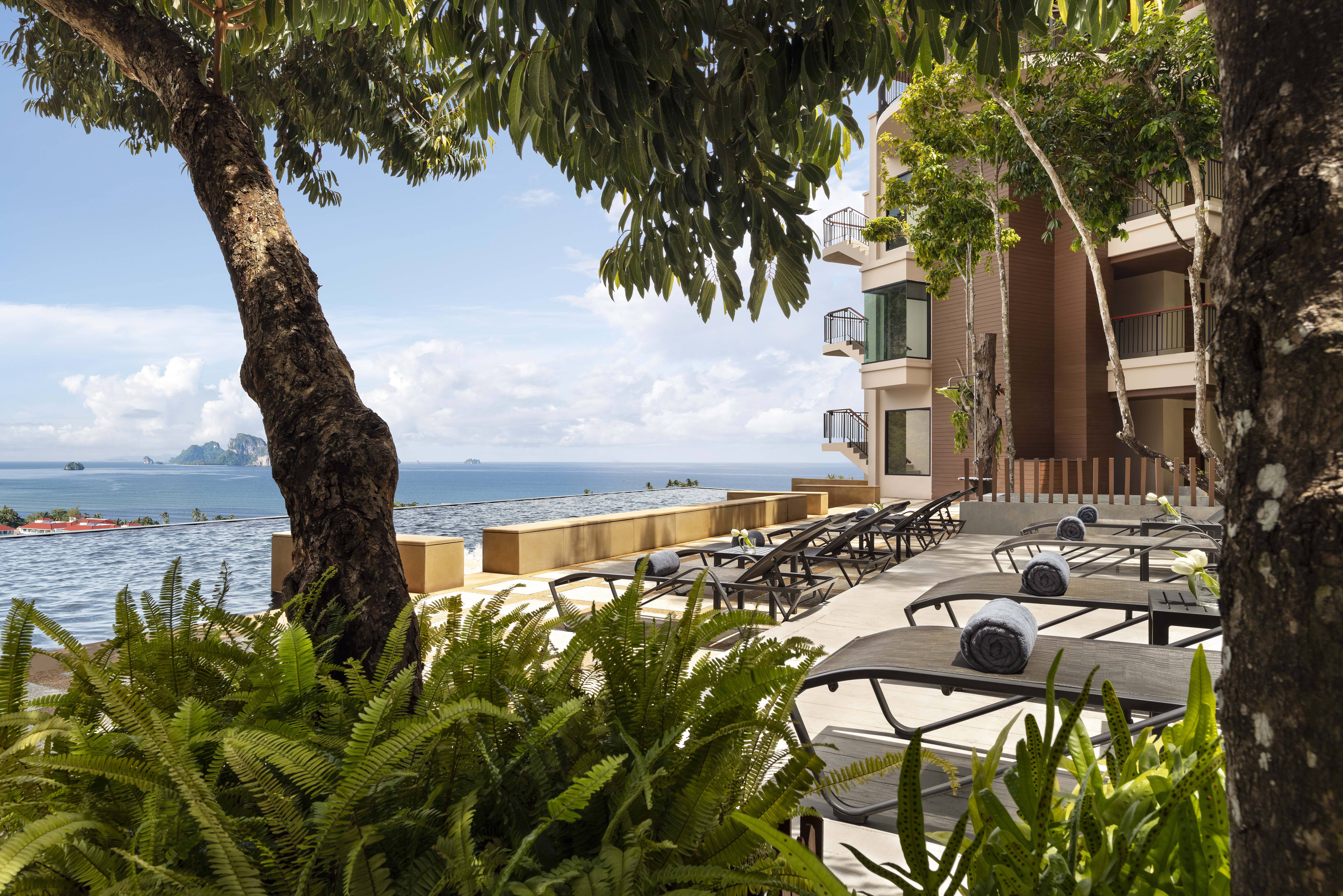 Ligbedjes bij het infinity zwembad in het Avani Ao Nang Cliff Krabi Resort in Thailand