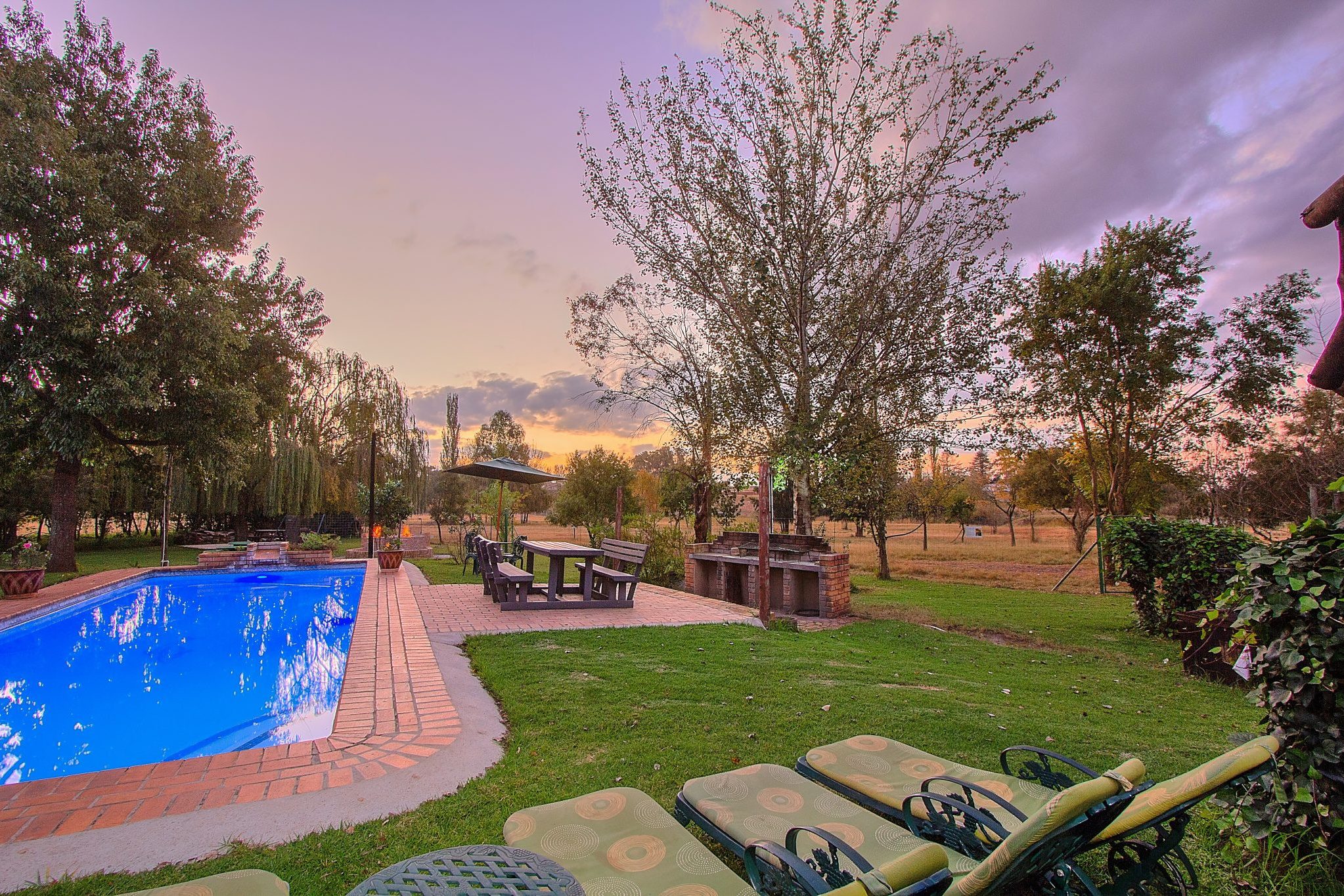 zuid-afrika-johannesburg-airport-game-lodge-zwembad-met-ligbedden-zondsondergang