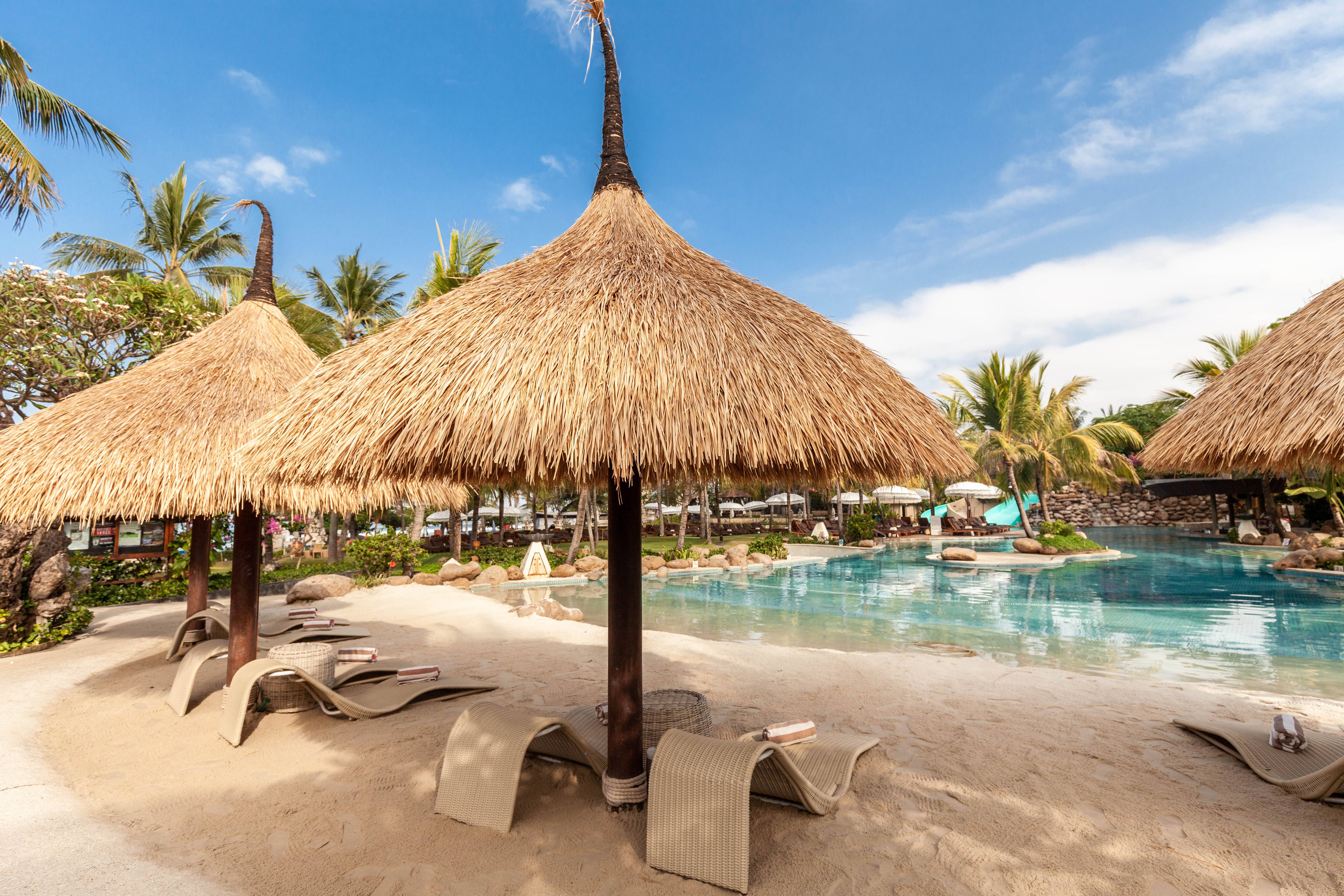 Indonesie-Bali-Legian-Bali-Mandira-Beach-Resort-en-Spa-ligbedden-zwembad