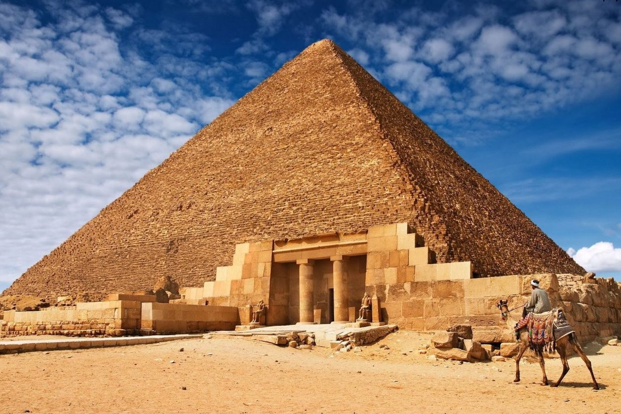 Ritje op een kameel bij de piramides van Gizeh bij Cairo in Egypte