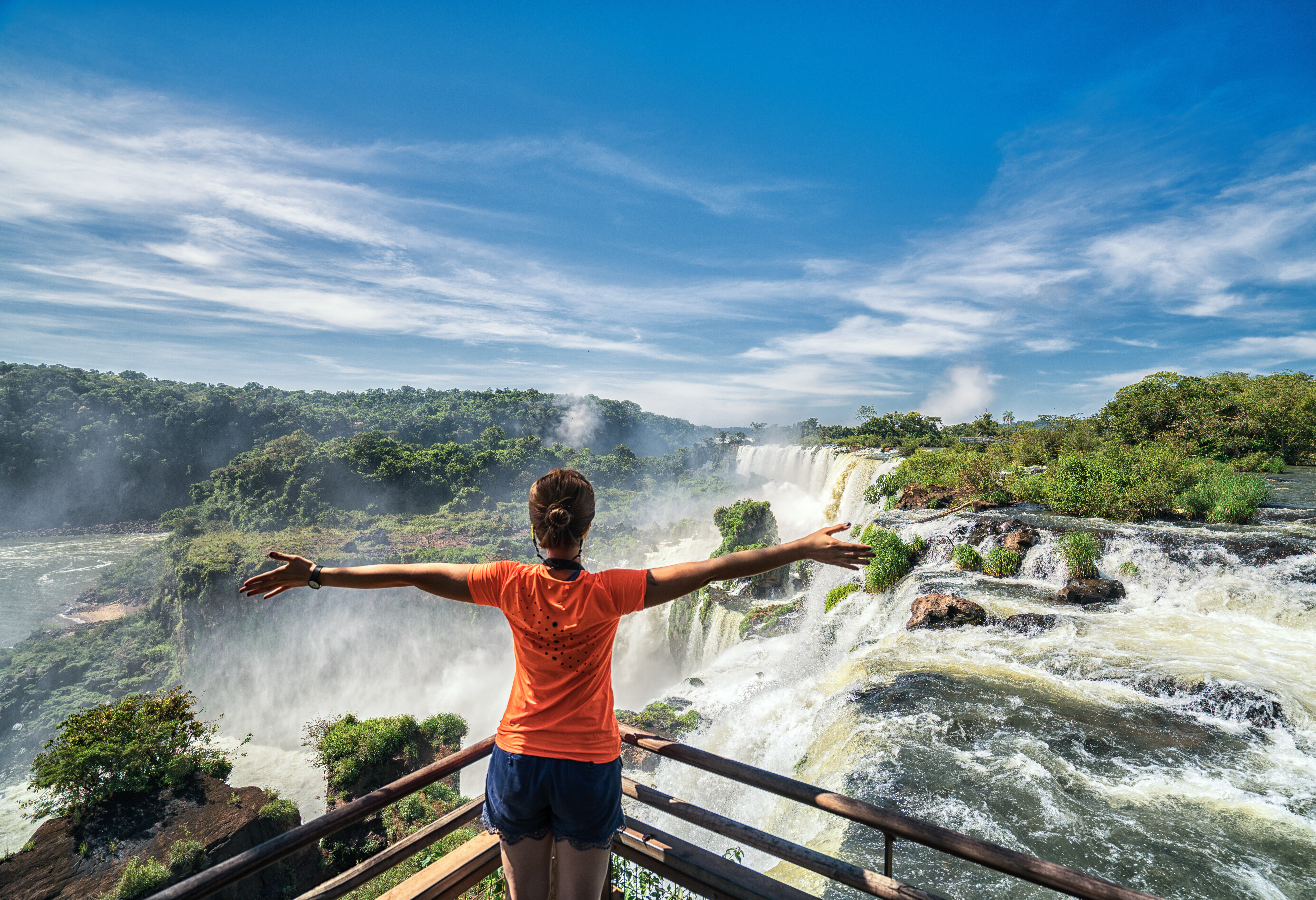 Vrouw kijkt uit over Iguazu waterval Argentinië