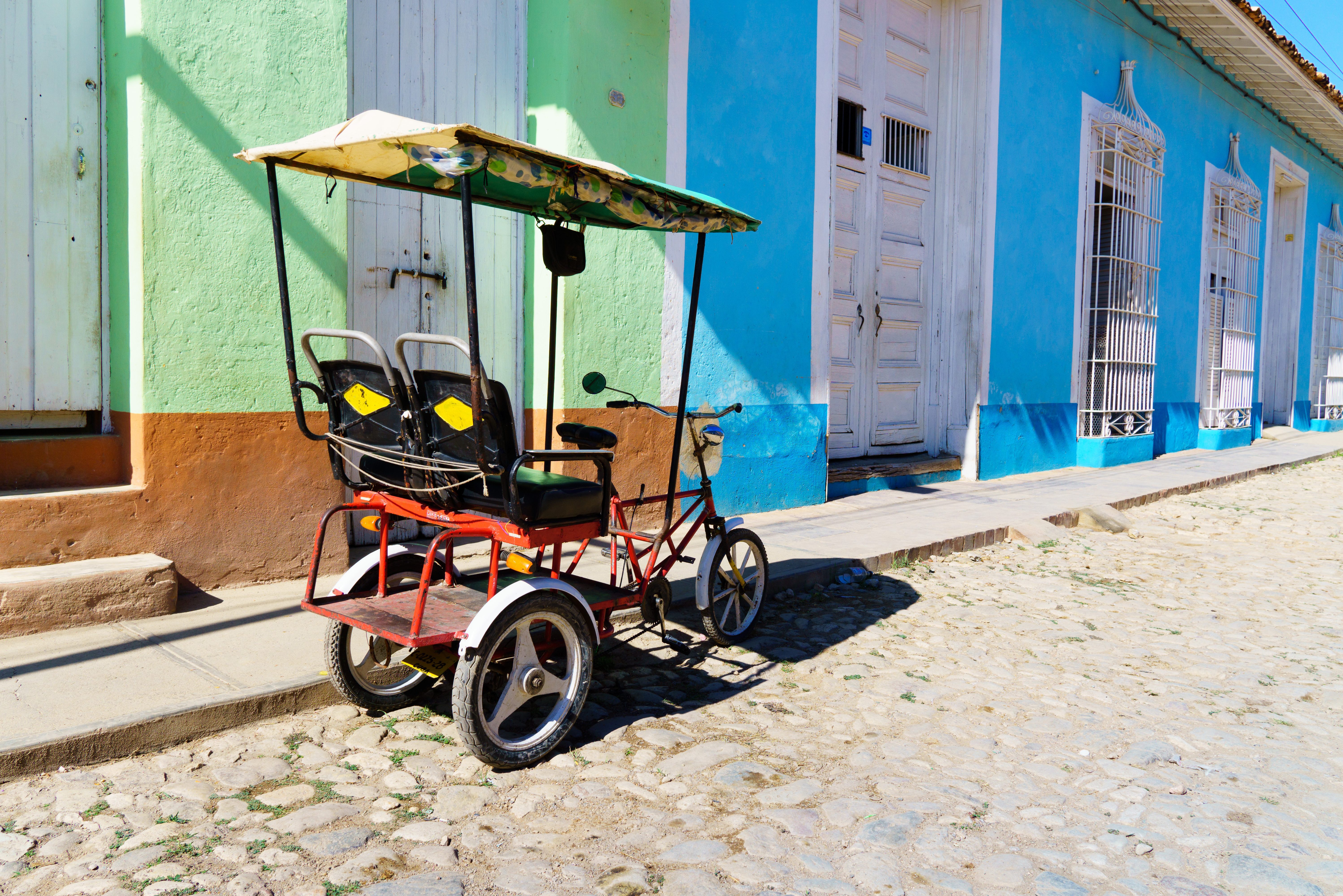 Bicitaxi in kleurrijk smal straatje in Trinidad in Cuba