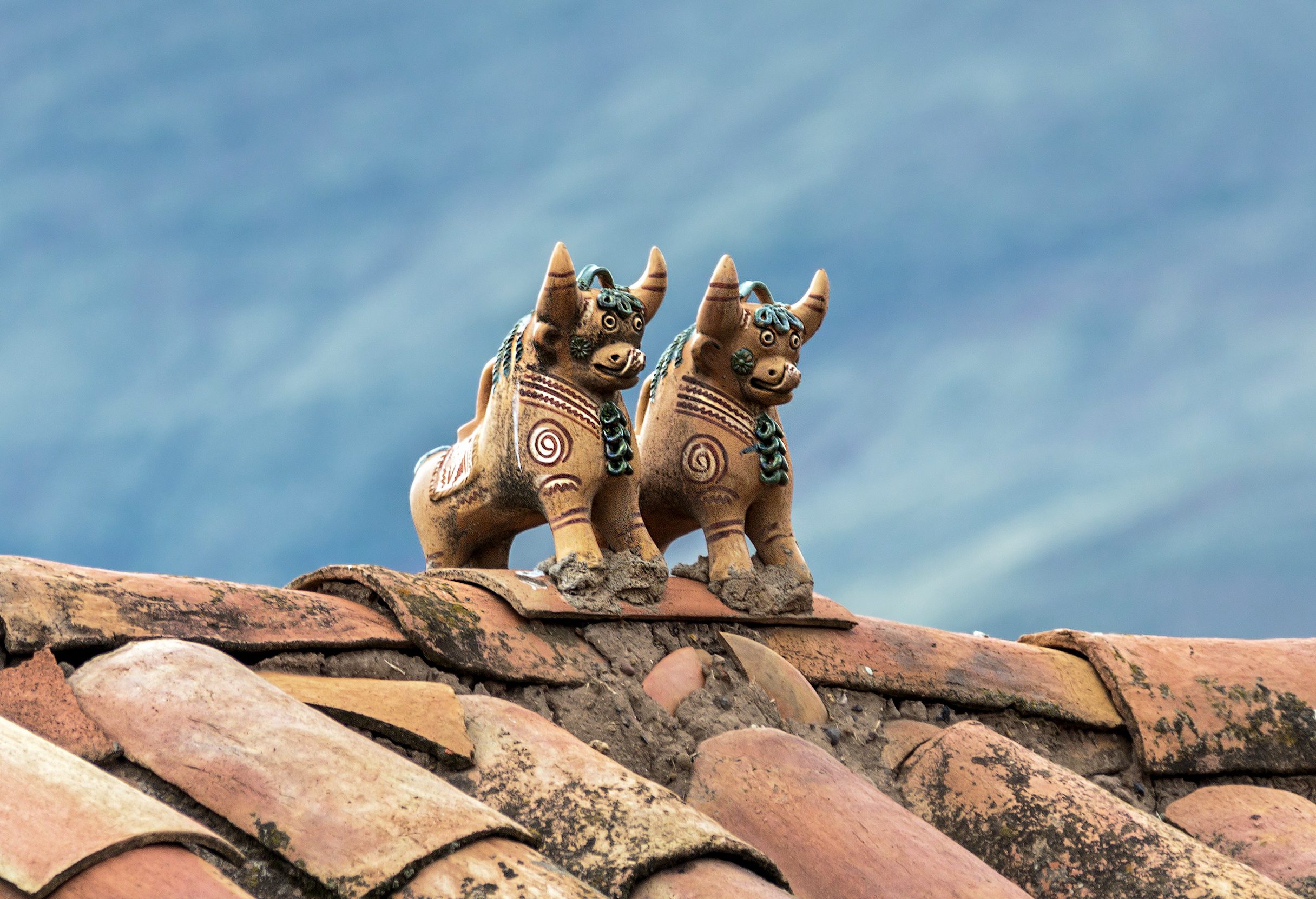 Pucara stiertjes op het dak van een huis in Peru