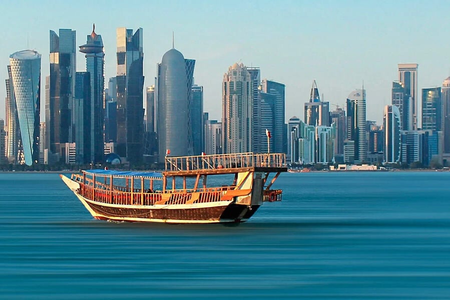 Dhow cruise bij zonsondergang langs de skyline van Doha in Qatar